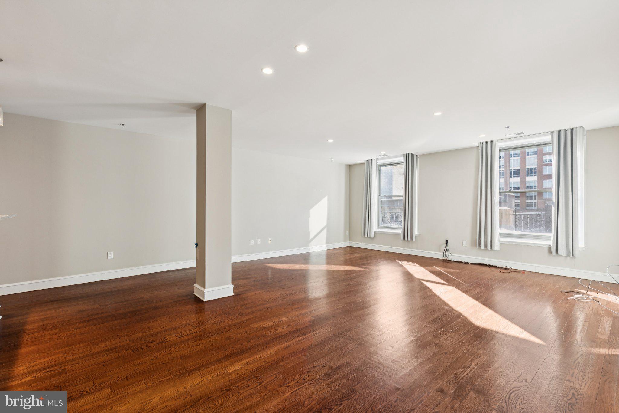 1811 Chestnut Street, Unit 701 Philadelphia, PA 19103 - Photo 12 of 26 a view of an empty room with wooden floor and a window
