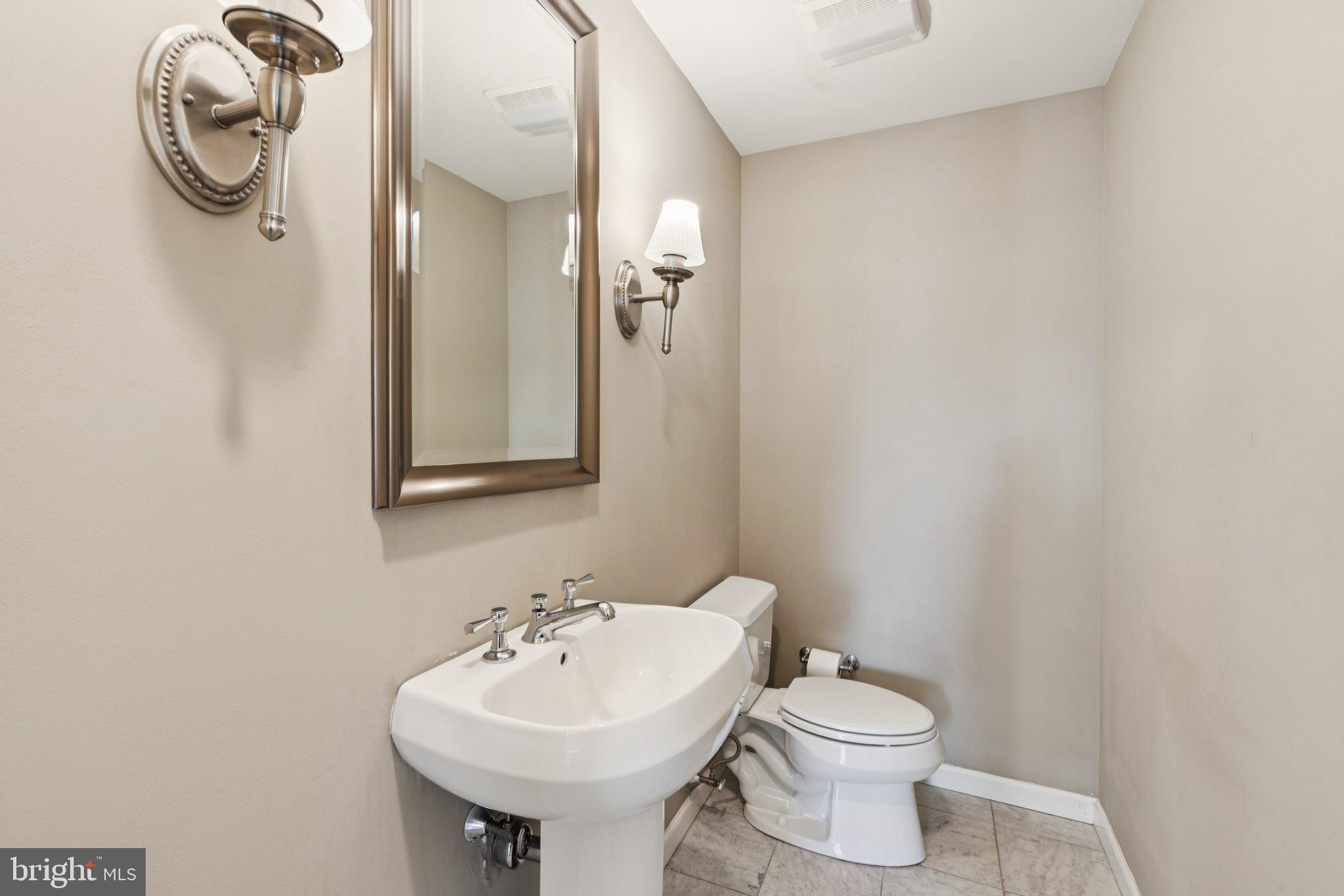 1811 Chestnut Street, Unit 701 Philadelphia, PA 19103 - Photo 13 of 26 a bathroom with a sink toilet and mirror