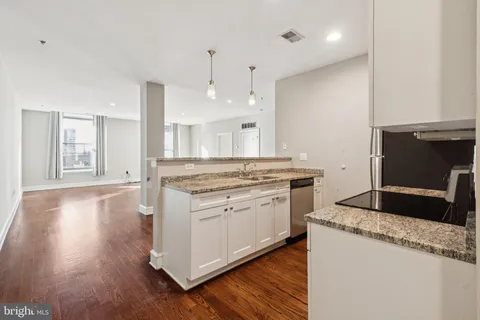 a kitchen with a stove and a wooden floor