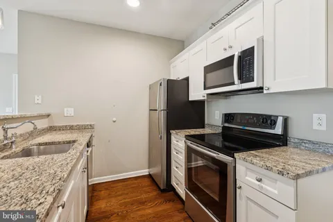 a kitchen with stainless steel appliances granite countertop a sink stove and microwave