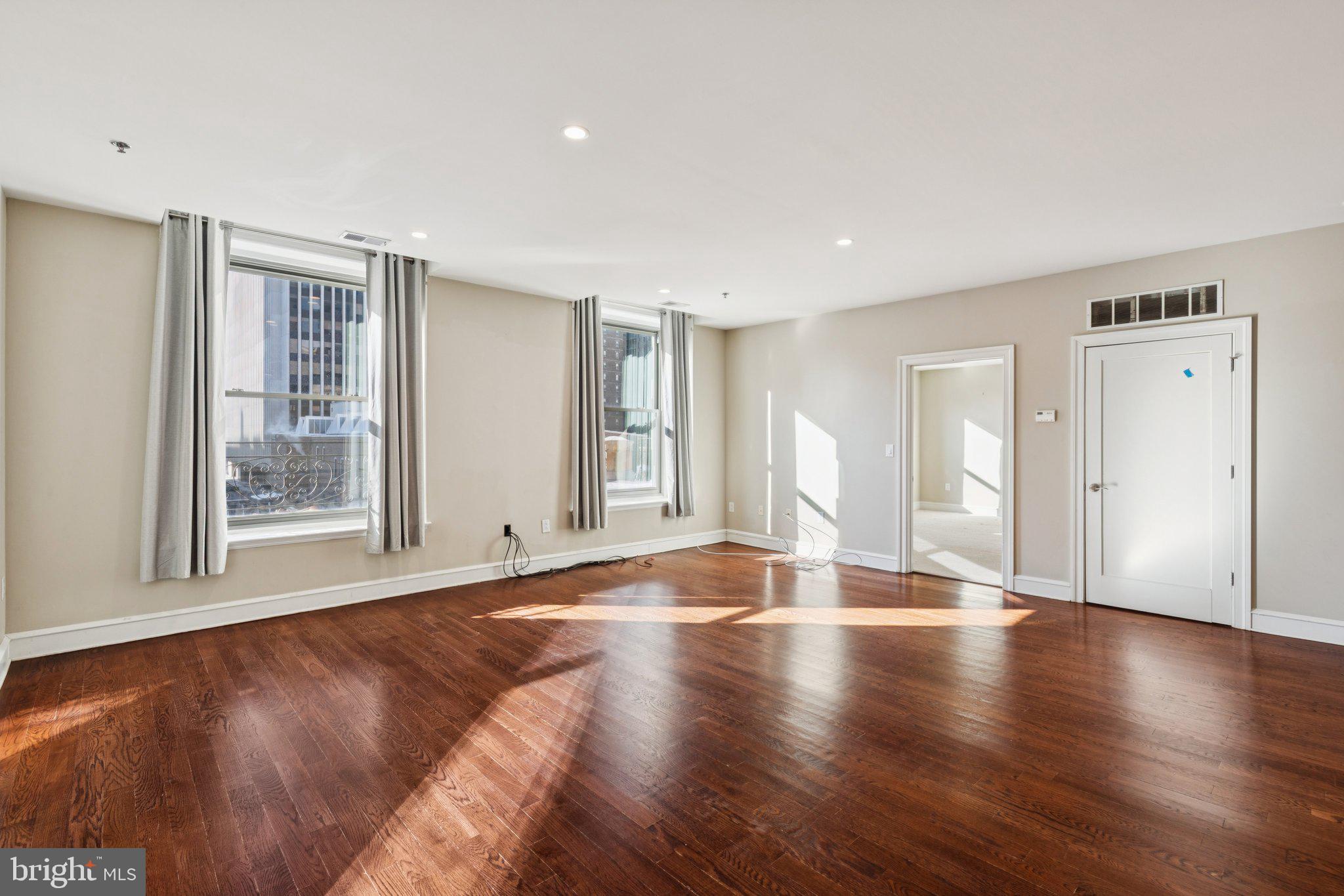 1811 Chestnut Street, Unit 701 Philadelphia, PA 19103 - Photo 8 of 26 a view of an empty room with wooden floor and a window