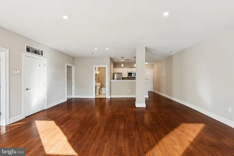 a view of a kitchen with wooden floor and a refrigerator