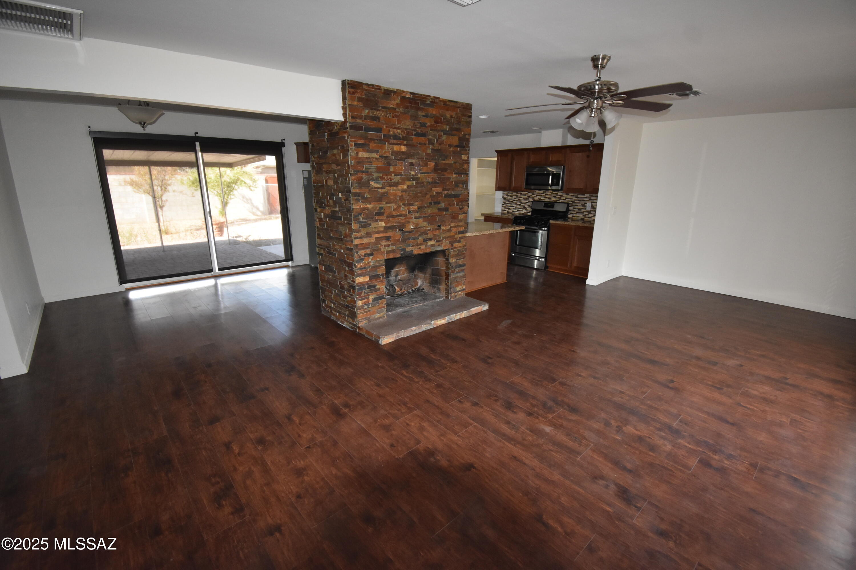 5501 East Spring Street Tucson, AZ 85712 - Photo 13 of 32 a view of empty room with wooden floor and fireplace