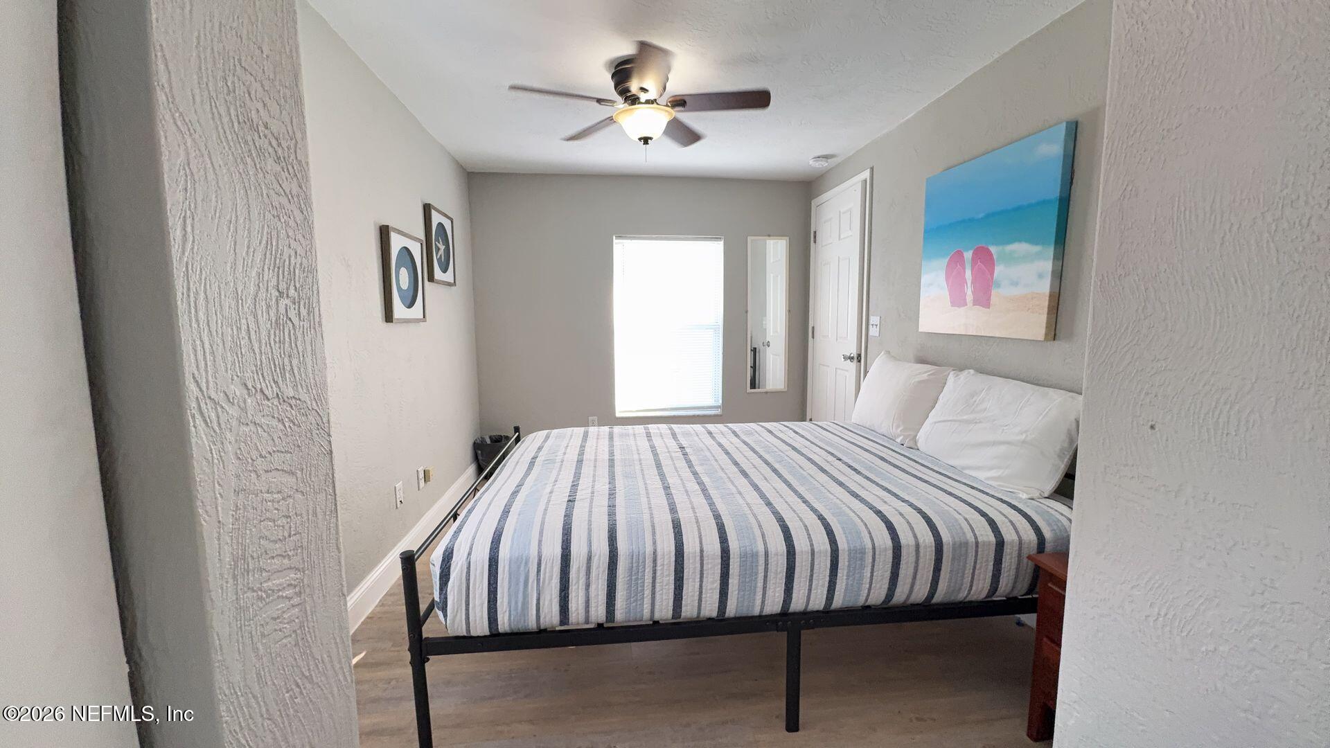 108 South 5th Street, Unit 2B Flagler Beach, FL 32136 - Photo 11 of 14 a bedroom with a bed and a chandelier