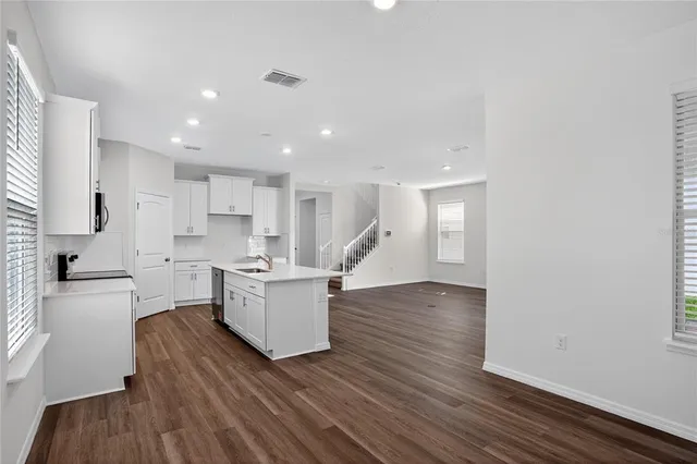 a view of a kitchen with wooden floor and a window