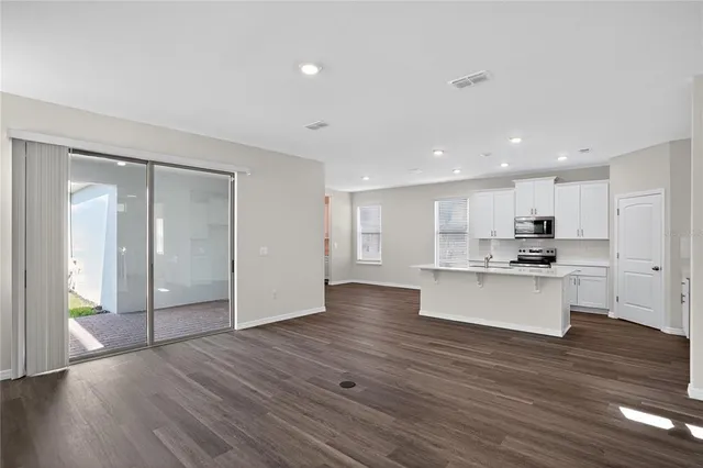 a kitchen with stainless steel appliances kitchen island wooden floors and white cabinets