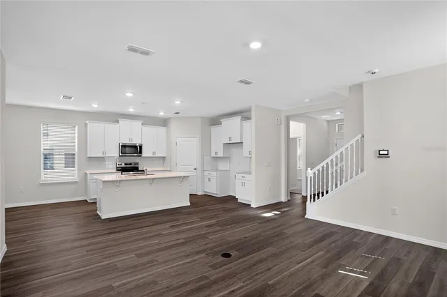 a view of kitchen with kitchen island wooden cabinets and refrigerator
