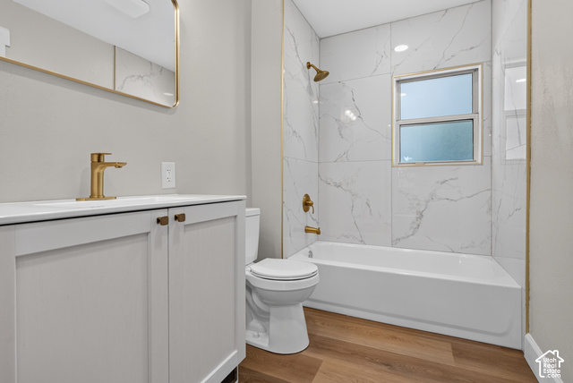 147 Center Street Clearfield, UT 84015 - Photo 25 of 55 Modern vanity with integrated sink, gold-finish fixtures, white tile shower surround, and wood-finish flooring