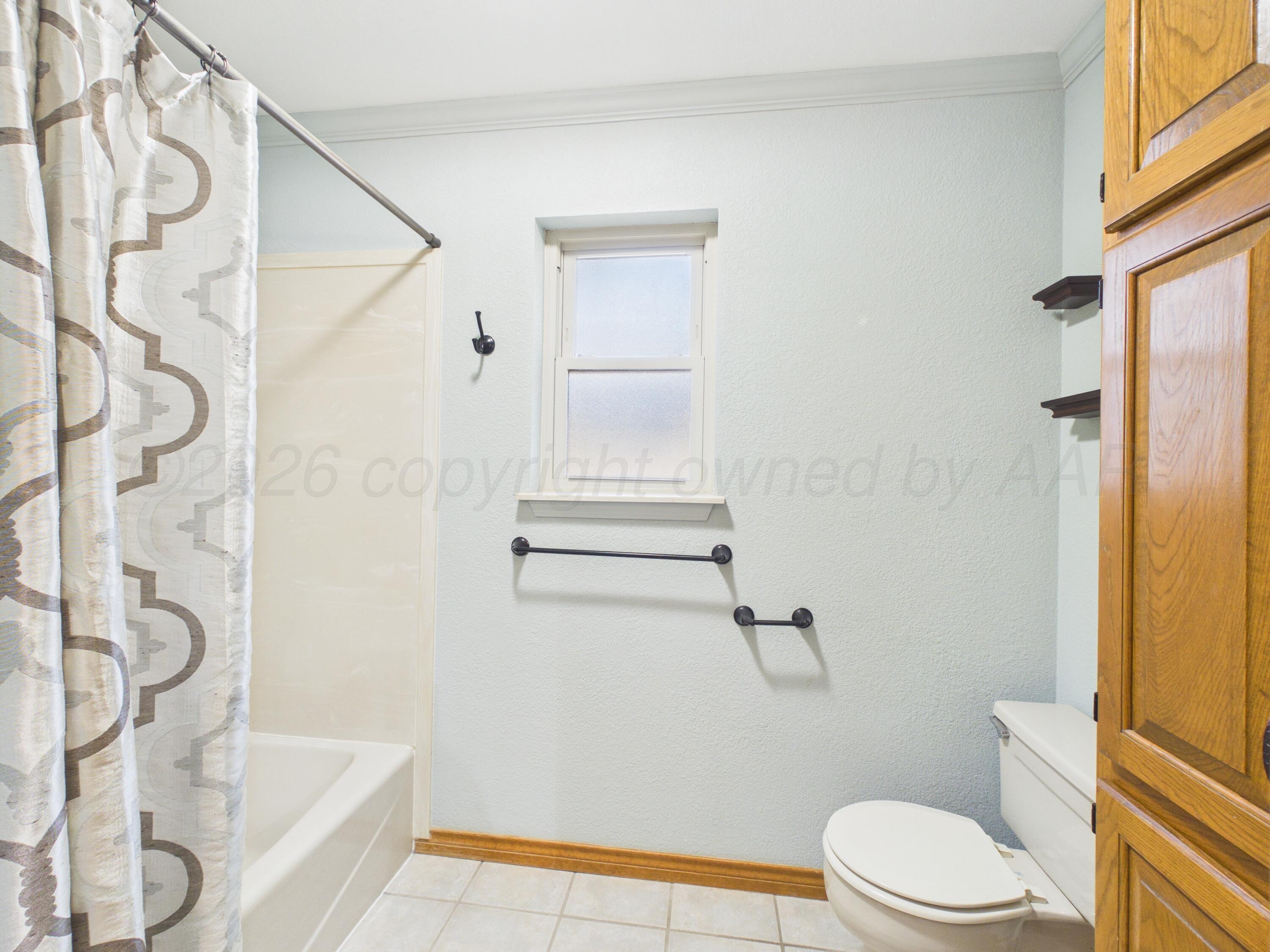 506 Robin Road Dumas, TX 79029 - Photo 11 of 31 a white toilet sitting next to a bath tub