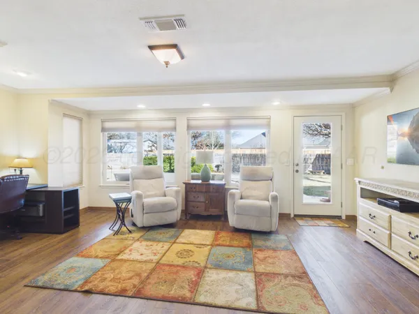 a living room with furniture and a wooden floor