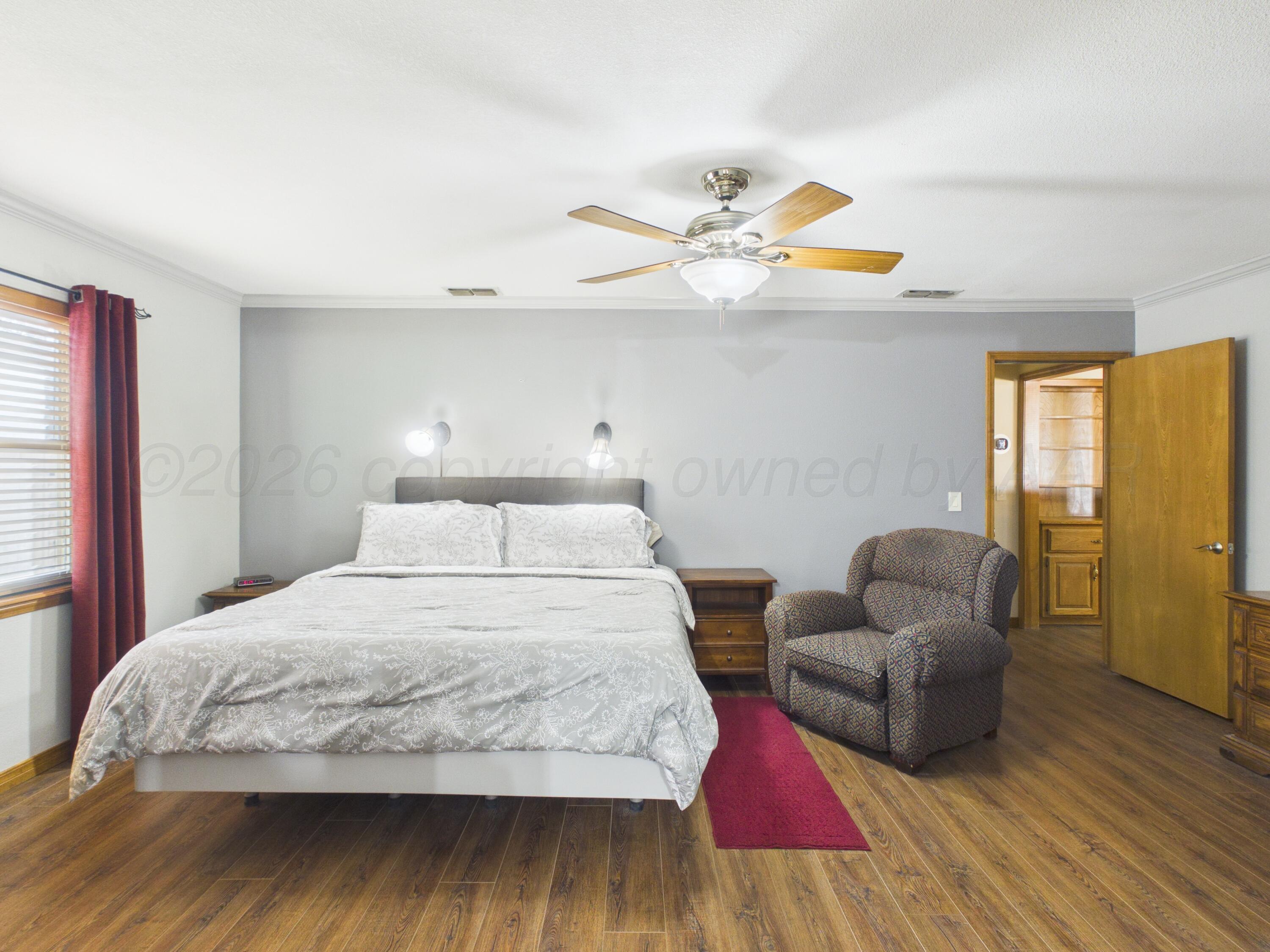 506 Robin Road Dumas, TX 79029 - Photo 27 of 31 a bedroom with a bed and wooden floor