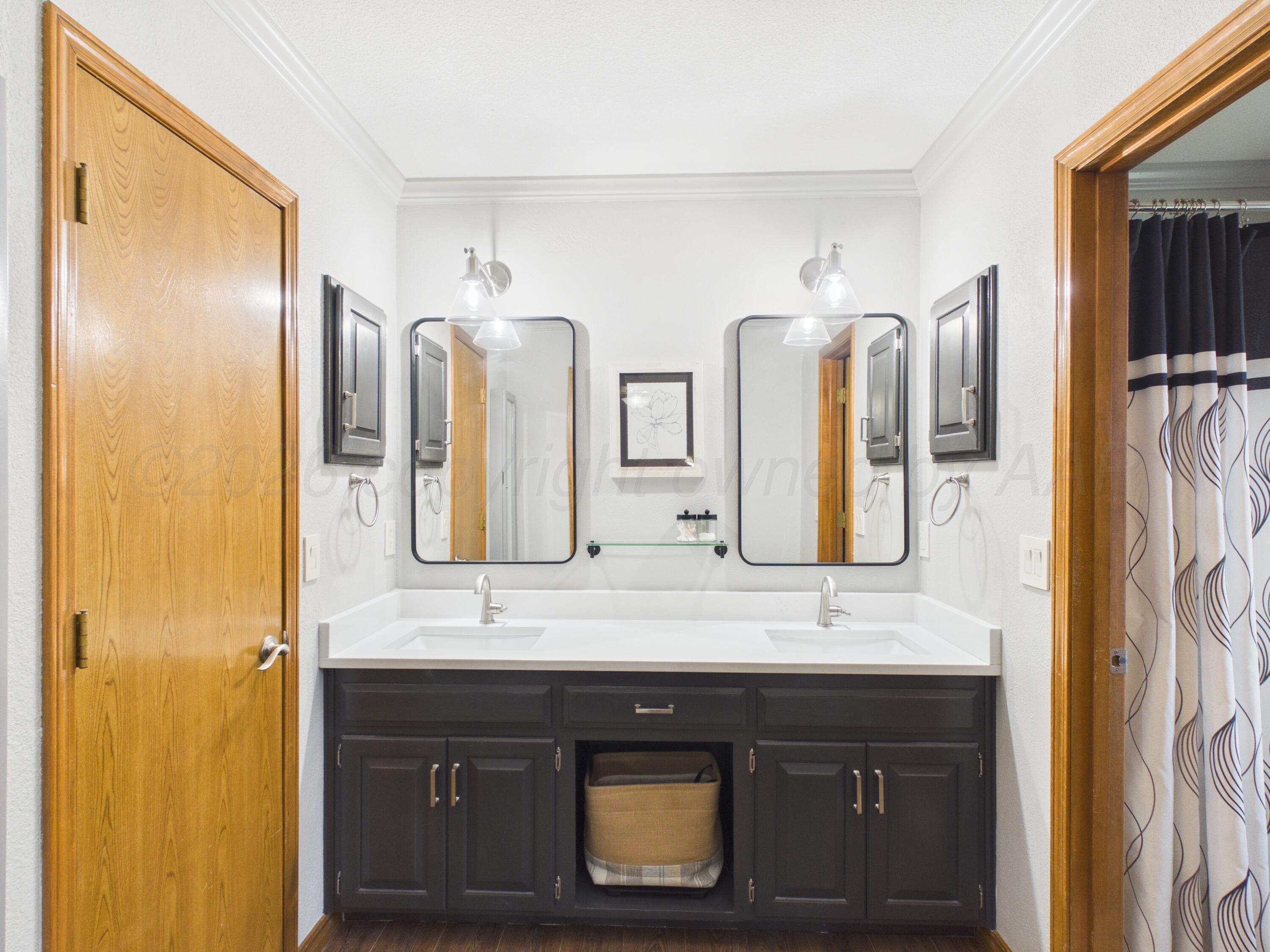 506 Robin Road Dumas, TX 79029 - Photo 28 of 31 a bathroom with double vanity and a mirror