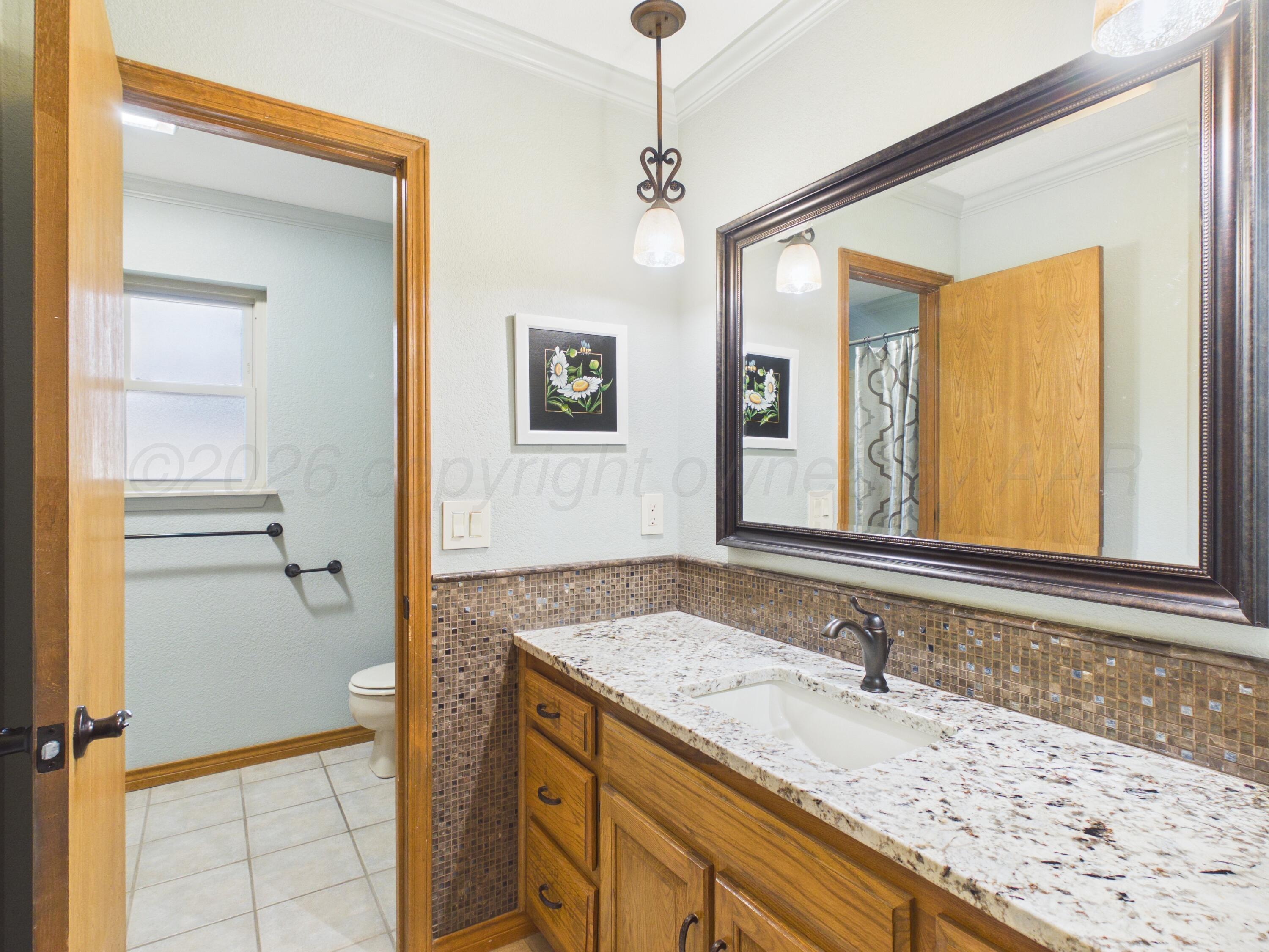 506 Robin Road Dumas, TX 79029 - Photo 10 of 31 a bathroom with a granite countertop sink and a mirror