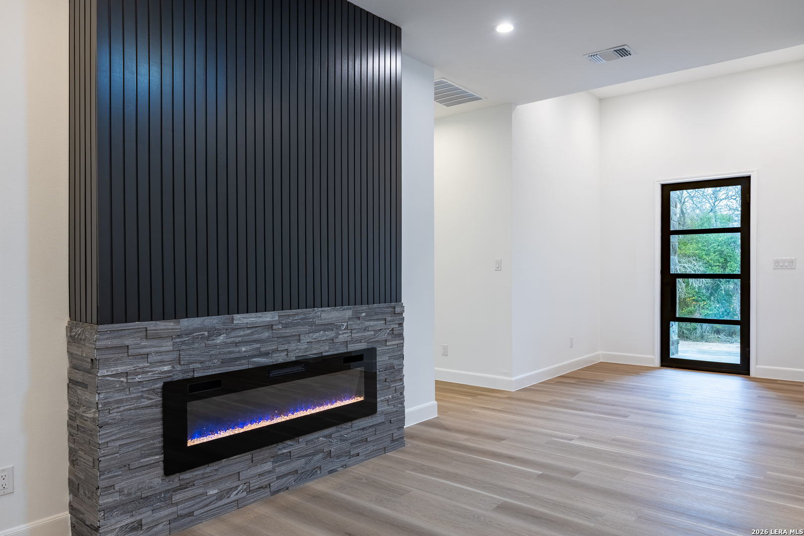 8221 Old Austin Road Selma, TX 78154 - Photo 12 of 28 a view of an empty room with wooden floor and a fireplace