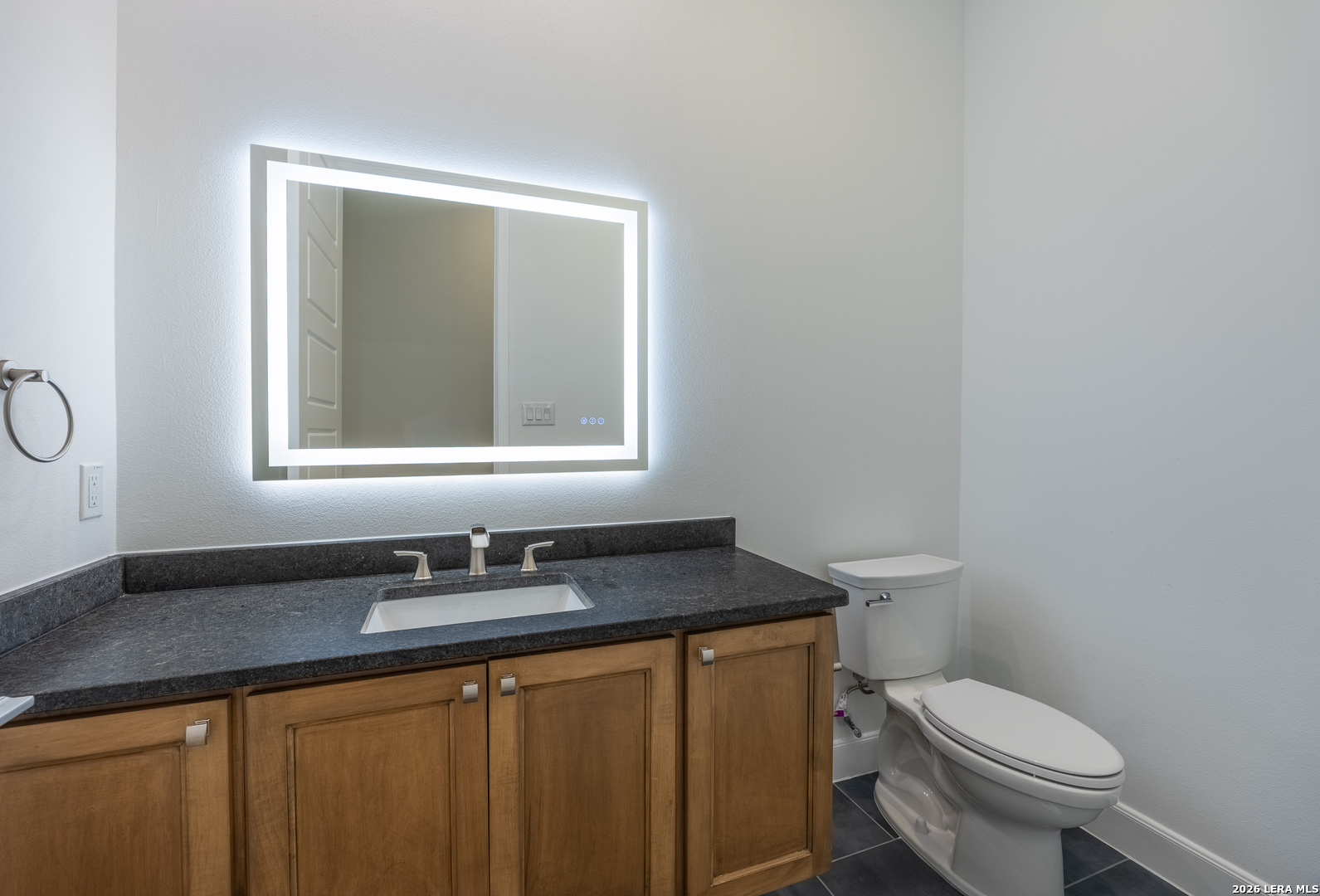 8221 Old Austin Road Selma, TX 78154 - Photo 15 of 28 a bathroom with a granite countertop toilet a sink and a mirror