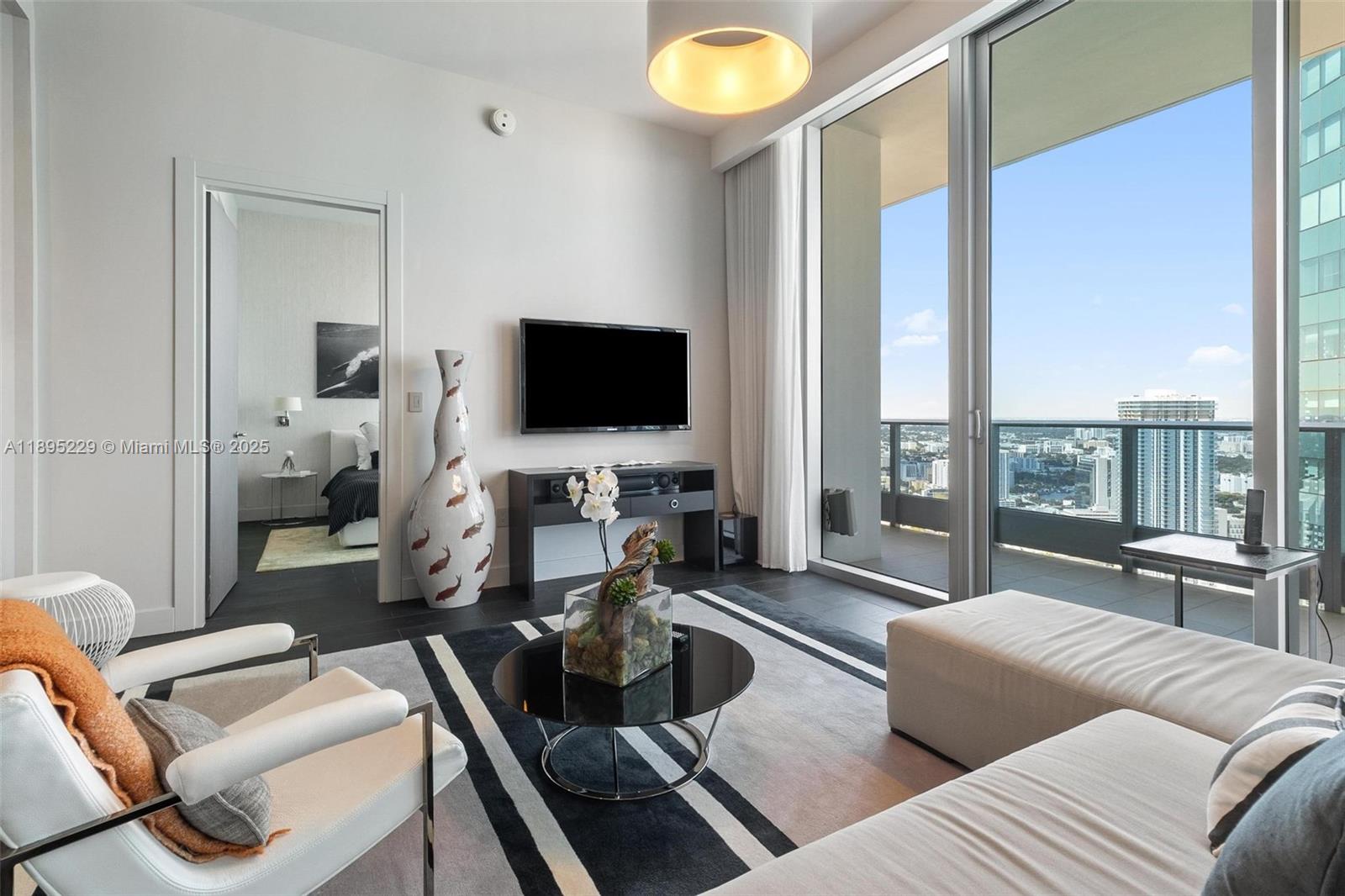 200 Biscayne Blvd Way, Unit 5211 Miami, FL 33131 - Photo 10 of 32 a living room with furniture and a flat screen tv