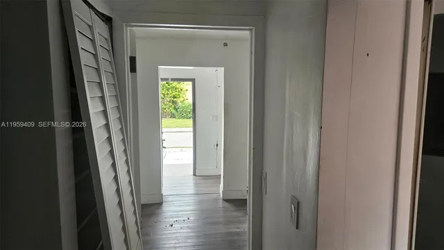 a view of a hallway with wooden floor and a glass door