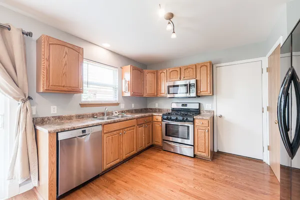 a kitchen with stainless steel appliances granite countertop a stove a sink and a refrigerator