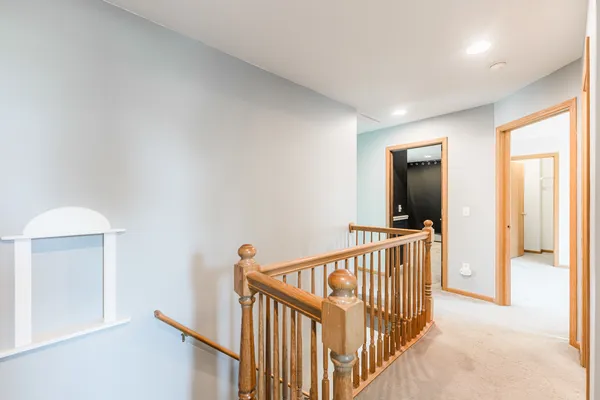 a view of a hallway with a bedroom and windows