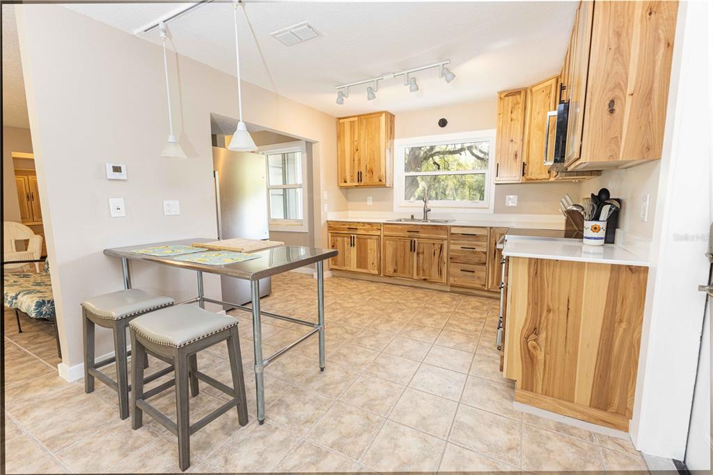 5175 Azalea Circle Dade City, FL 33523 - Photo 2 of 34 a kitchen with a sink dining table and chairs