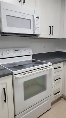 a kitchen with cabinets and a refrigerator
