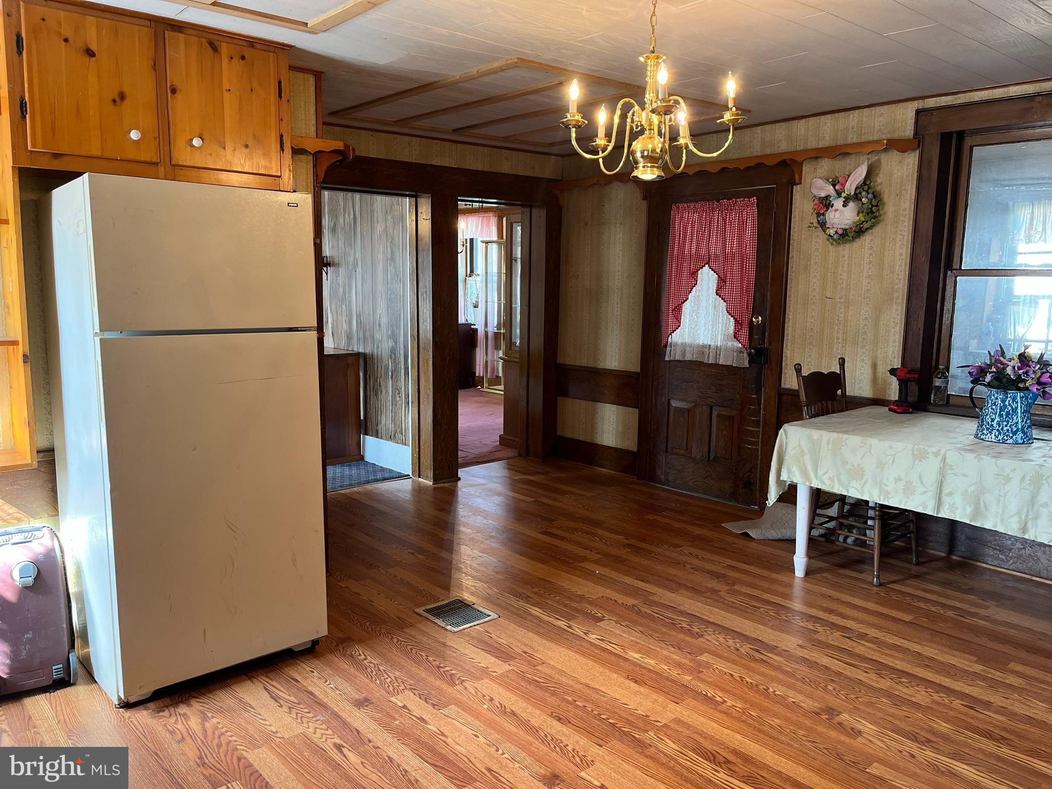 4164 Penns Valley Road Spring Mills, PA 16875 - Photo 11 of 49 a dining room with wooden floor a chandelier a wooden table and chairs