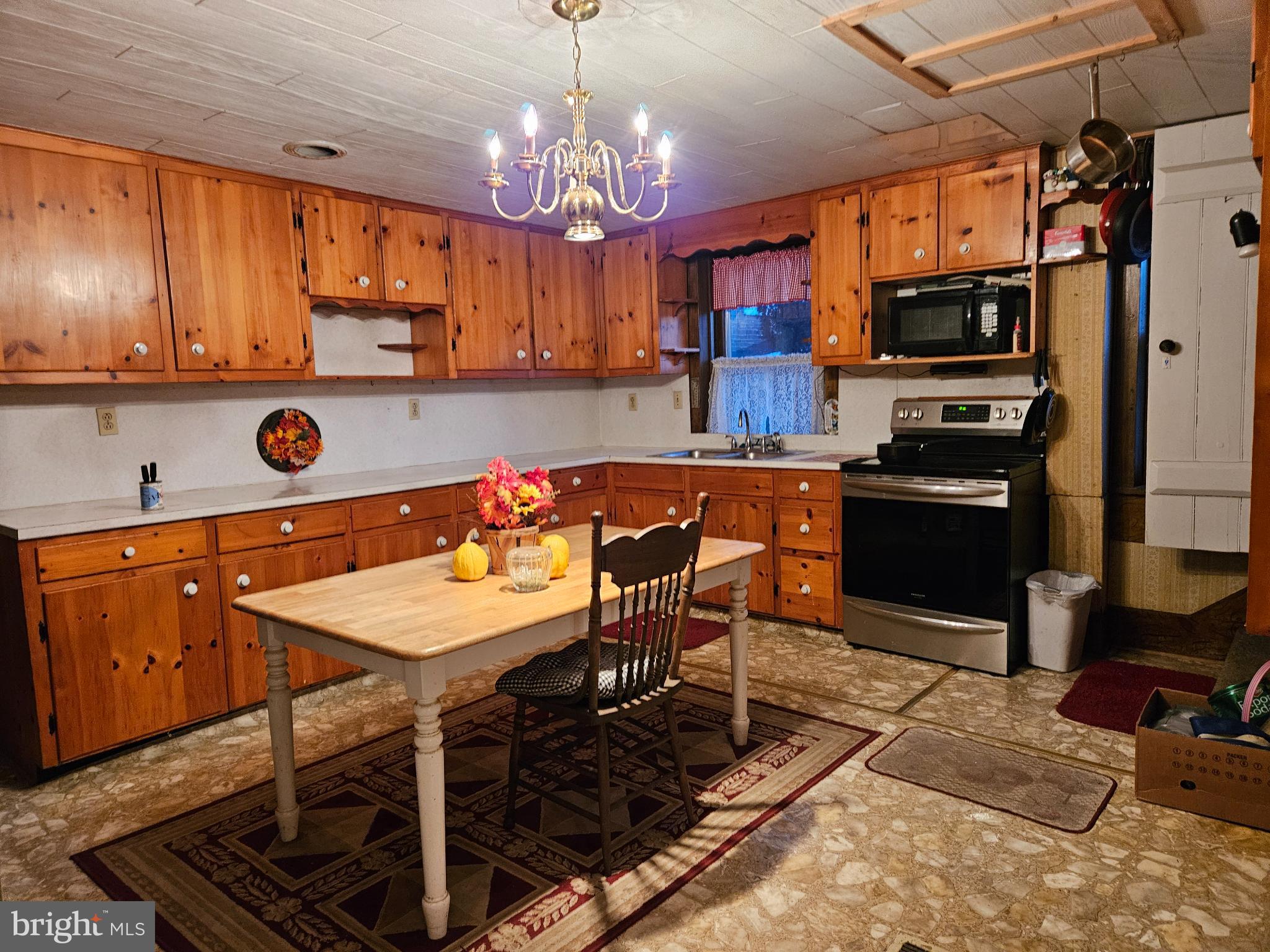 4164 Penns Valley Road Spring Mills, PA 16875 - Photo 4 of 34 a kitchen with stainless steel appliances granite countertop a stove refrigerator a sink dishwasher a dining table and chairs with wooden floor