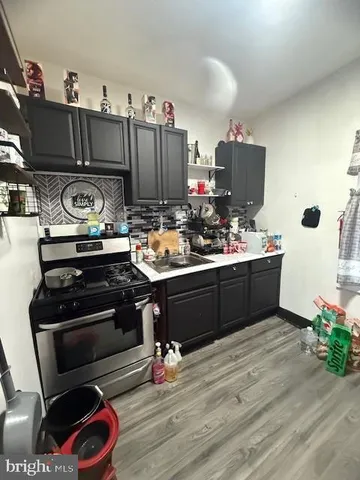 a kitchen with a stove and a wooden floor