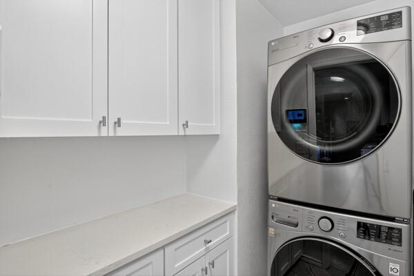 6331 North Jim Miller Road Dallas, TX 75228 - Photo 20 of 28 Laundry room featuring cabinet space and estacked washer and dryer