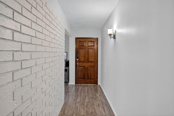 6331 North Jim Miller Road Dallas, TX 75228 - Photo 24 of 28 Doorway to outside with brick wall and wood finished floors