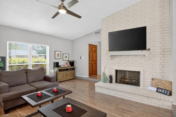 6331 North Jim Miller Road Dallas, TX 75228 - Photo 3 of 28 Living room with lofted ceiling, wood finished floors, a fireplace, and ceiling fan