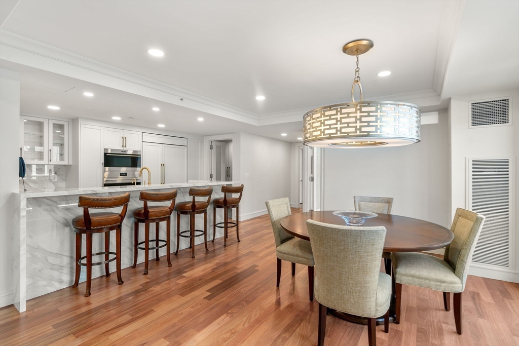 4 Battery Wharf, Unit 4604 Boston, MA 02109 - Photo 11 of 39 a view of a dining room with furniture wooden floor and chandelier