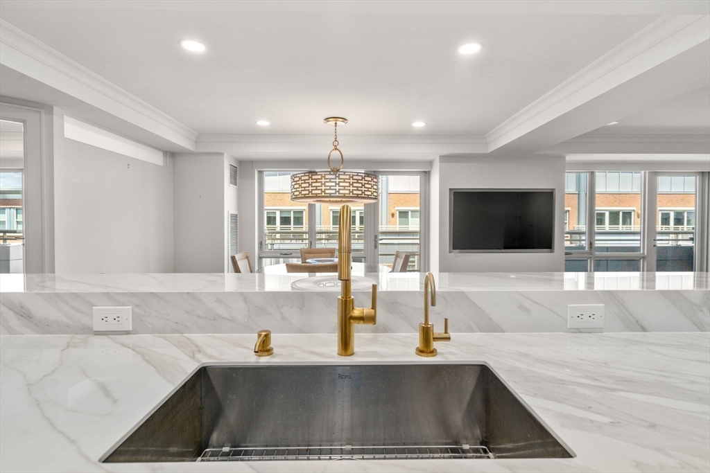 4 Battery Wharf, Unit 4604 Boston, MA 02109 - Photo 18 of 39 a kitchen with stainless steel appliances kitchen island granite countertop a sink and a granite counter tops