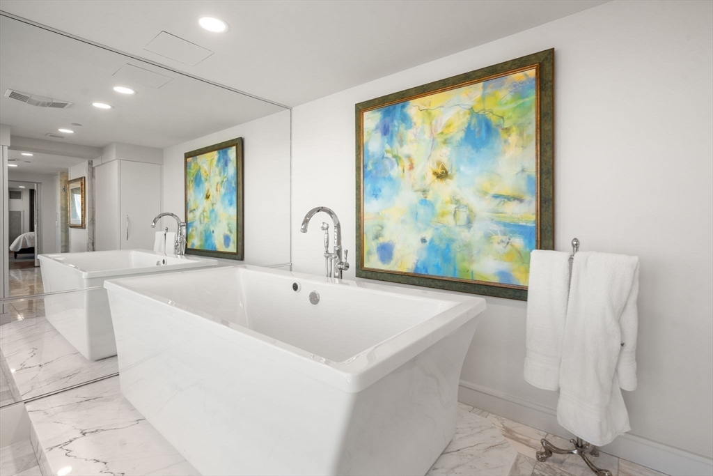 4 Battery Wharf, Unit 4604 Boston, MA 02109 - Photo 34 of 39 a large tub sitting in a bathroom next to a window