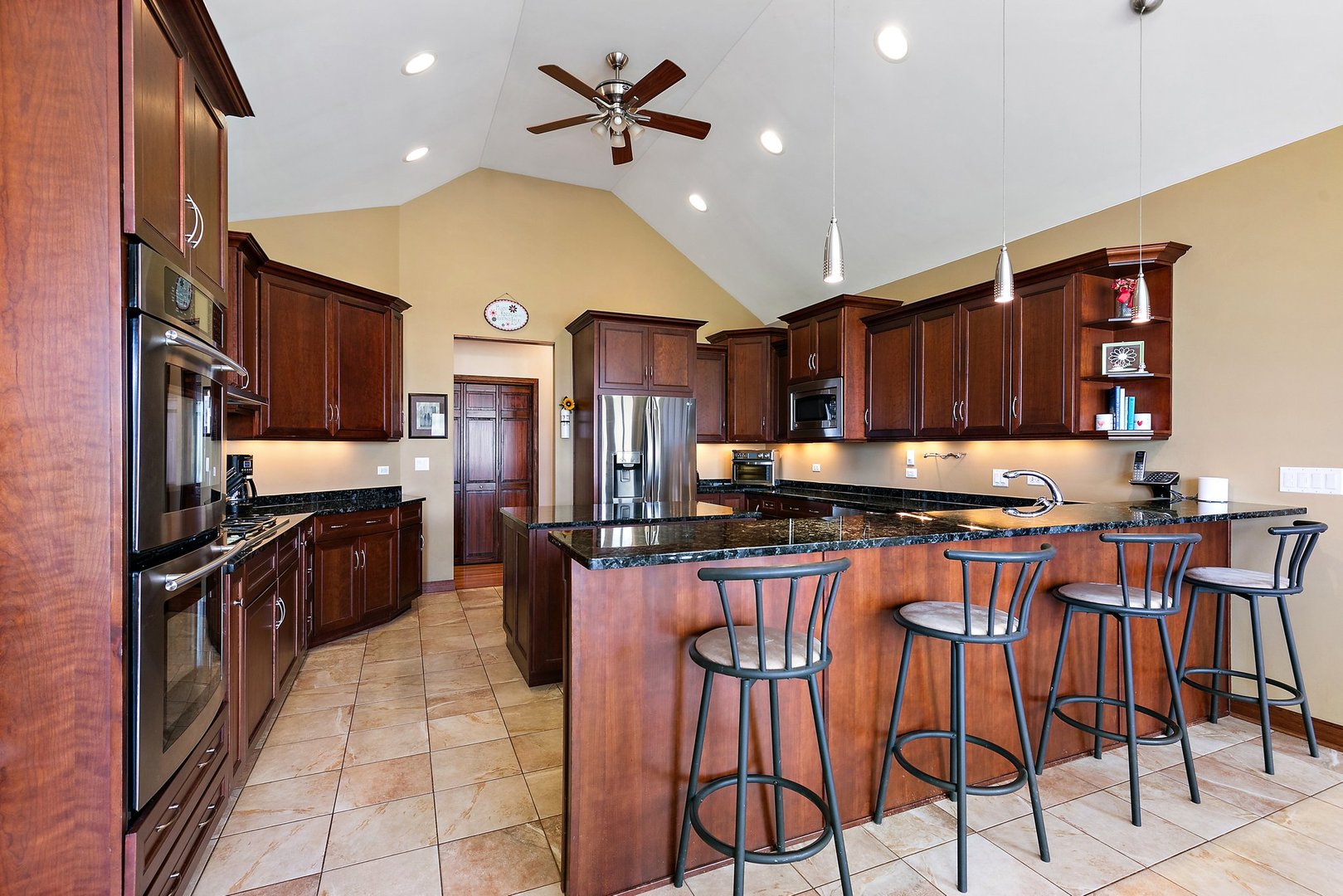 550 Maplewood Road Somonauk, IL 60552 - Photo 13 of 91 a kitchen with stainless steel appliances kitchen island granite countertop a table chairs refrigerator and cabinets