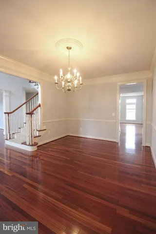 a view of a room with wooden floor chandelier and windows