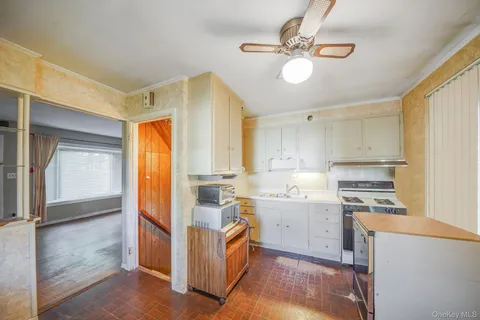 a kitchen that has a lot of cabinets in it and wooden floors