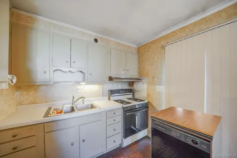 a kitchen with cabinets stainless steel appliances and wooden floor