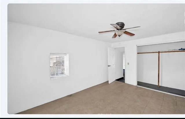 a view of a room with a ceiling fan and carpet