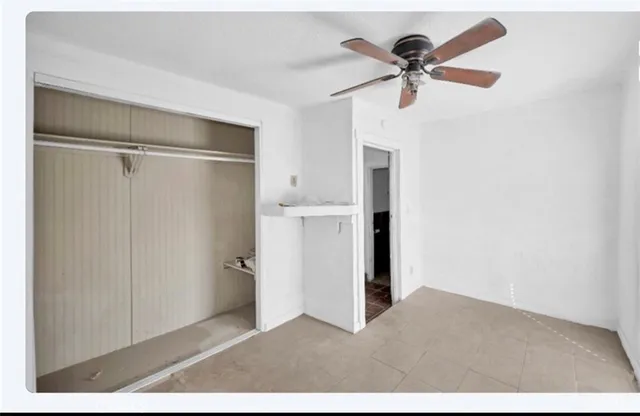 a view of empty room with cabinet and ceiling fan