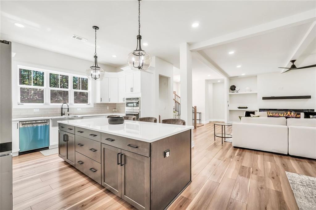 5567 Tyree Road Winston, GA 30187 - Photo 8 of 28 a large kitchen with kitchen island a stove a sink a center island and wooden floor