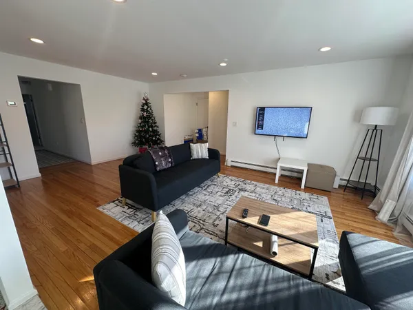 a living room with furniture and wooden floor