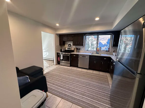 a large kitchen with stainless steel appliances kitchen island granite countertop a sink and cabinets