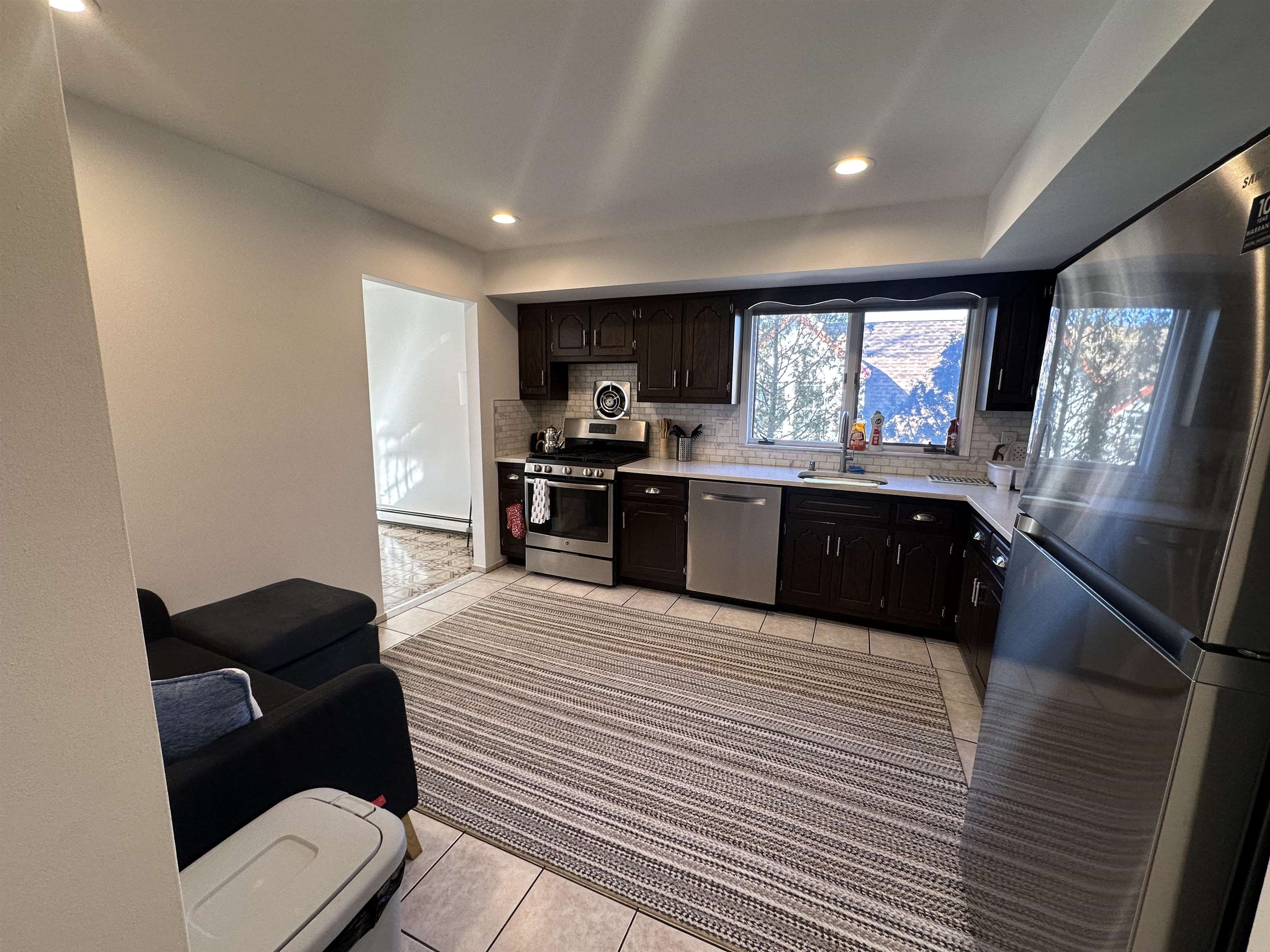 531 Day Avenue, Unit 1 Ridgefield, NJ 07657 - Photo 7 of 18 a large kitchen with stainless steel appliances kitchen island granite countertop a sink and cabinets