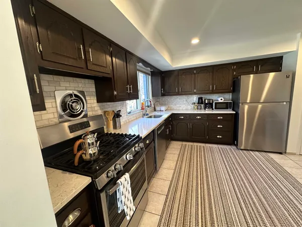 a kitchen with wooden cabinets a stove and a refrigerator