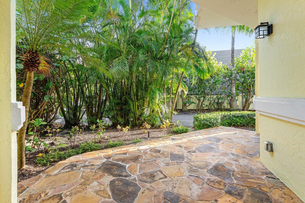 5109 North Ocean Boulevard, Unit H Ocean Ridge, FL 33435 - Photo 12 of 45 a view of yellow house with a yard and large trees