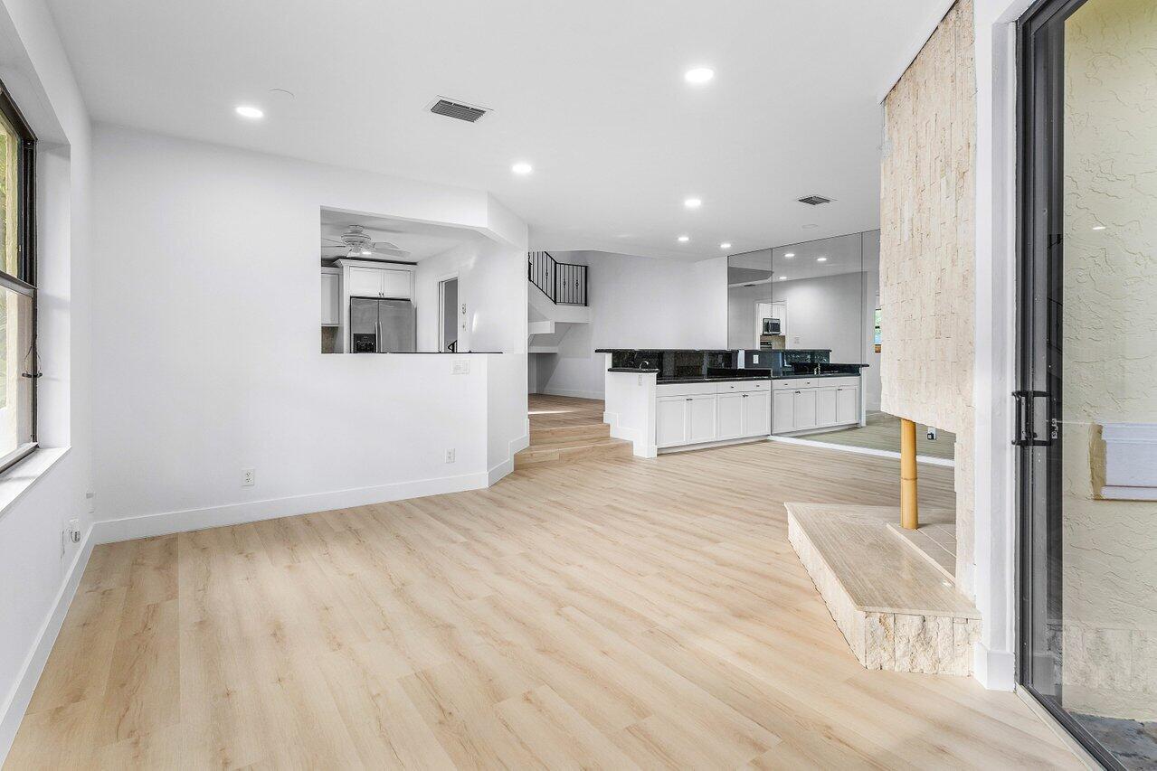 5109 North Ocean Boulevard, Unit H Ocean Ridge, FL 33435 - Photo 13 of 45 a view of a kitchen with kitchen island granite countertop wooden floor and stainless steel appliances