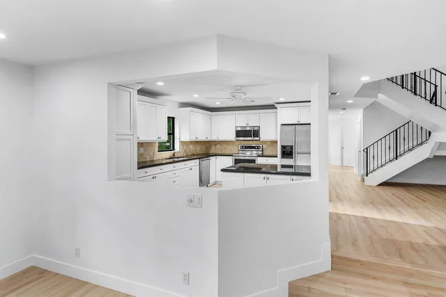 a kitchen with granite countertop a stove a sink and a microwave