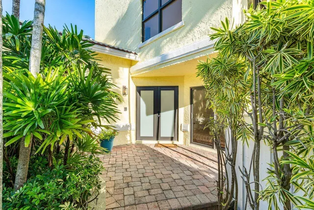a porch with potted plants and floor to ceiling window