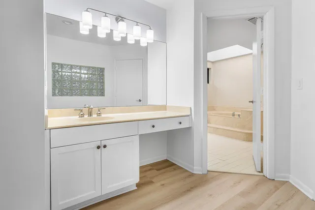 a spacious bathroom with a double vanity sink a mirror and a bathtub